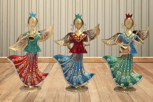 Three decorative figurines on a wooden floor with a clock on the wall.